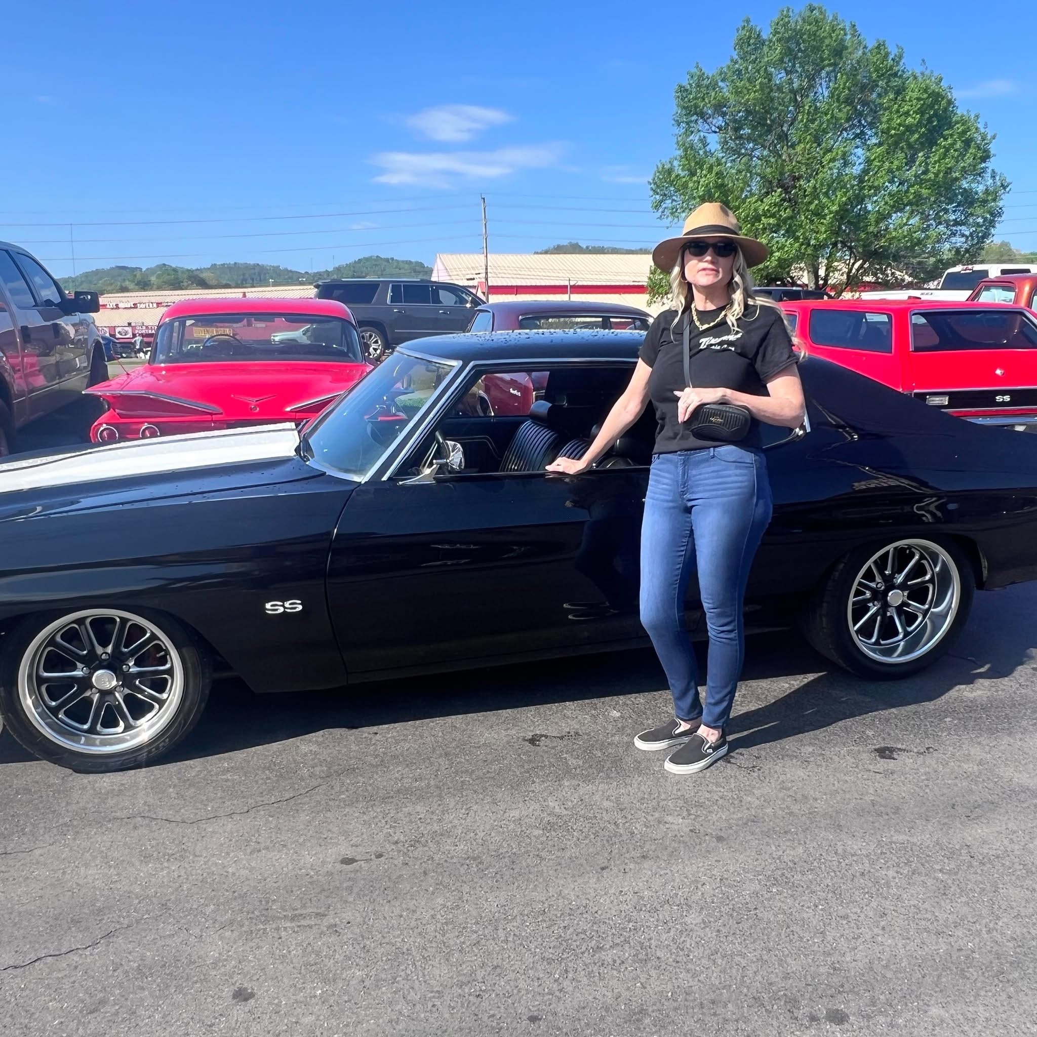 Cyndi Owens at a classic car auction with a Chevrolet SS