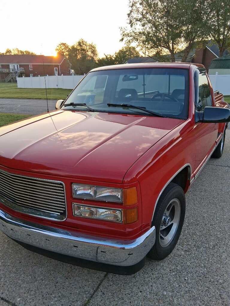 Red Chevrolet pickup truck, driveway at sunset